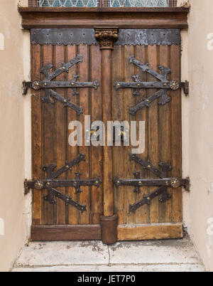 Old wooden oak arched gothic church doorway with black wrought iron hinges. Large wooden door with wrought-iron elements. Decorative door with fitting Stock Photo