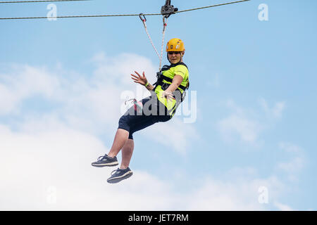 DOBRIS, CZECH REPUBLIC - JUNE 10, 2017.Young woman in the seat crashes down the rope across the valley. Centre harness Stock Photo