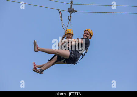 DOBRIS, CZECH REPUBLIC - JUNE 10, 2017. Young woman and girl in the seat crashes down the rope across the valley. Centre harness. Girl and woman on th Stock Photo