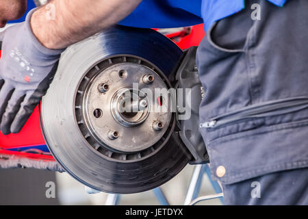 Automotive mechanic checking brake system. Vehicle maintenance in the ...