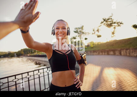 Runner girl giving high five in the park Stock Photo