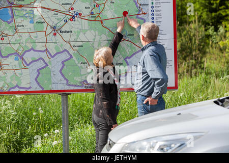 Senior happy couple finding location details on map while traveling by car Stock Photo