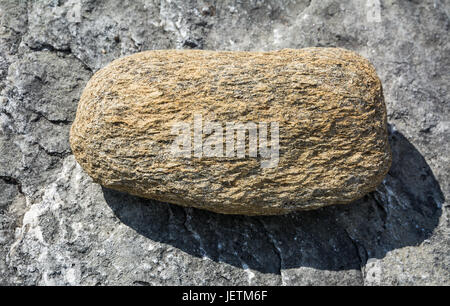 Big oval stone on rock in the mountains Stock Photo