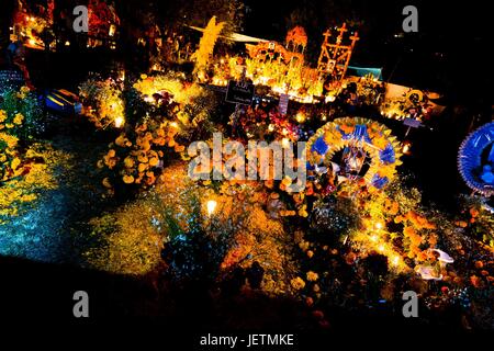 Richly decorated graves, covered by flowers, offerings and candles, are seen during the Day of the Dead celebration at the cemetery in Tzintzuntzan, Michoacan, Mexico, 2 November 2014. Day of the Dead (‚ÄòDia de Muertos‚Äô) is a syncretic religious | usage worldwide Stock Photo