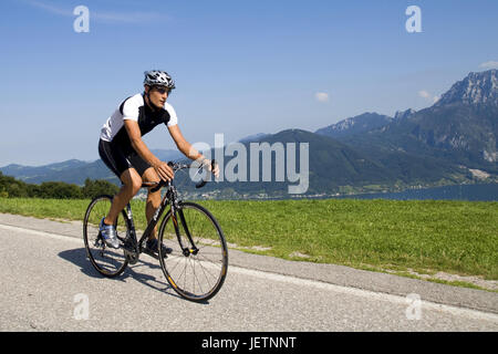 Man with the racing wheel in alpine scenery, Mann mit dem Rennrad in alpiner Landschaft Stock Photo