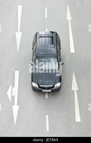 Car from above between roadway-direction arrows, Auto von oben zwischen Fahrbahn-Richtungspfeilen Stock Photo