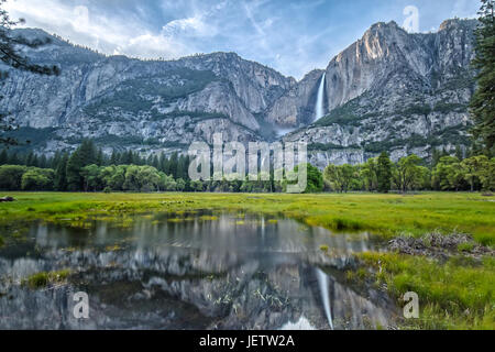 Yosemite Falls and its Reflection on the Water in the Valley Stock Photo