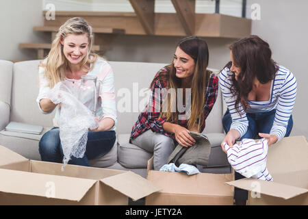 Friends unpacking carton boxes Stock Photo