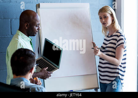 Colleagues standing by white board Stock Photo