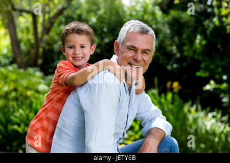 Smiling garndfather with grandson at yard Stock Photo