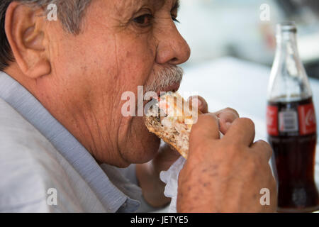 Local man eating a torta at a roadside restaurant in Oaxaca, Mexico Stock Photo