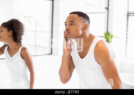 Couple checking their skin in bathroom Stock Photo