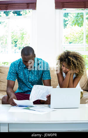 Worried young couple checking on bills Stock Photo