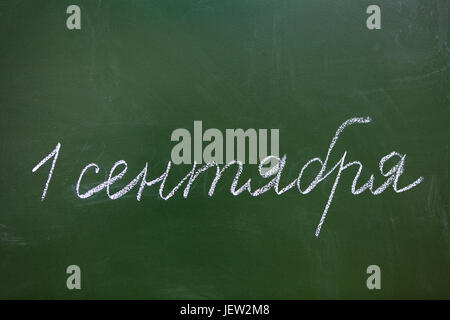 Inscription September 1 in Russian with white chalk on green blackboard Stock Photo