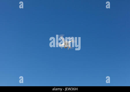 White copter hovering high in the sky Stock Photo