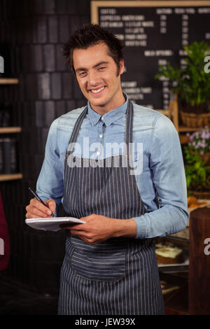 Waiter standing with notebook and pen Stock Photo