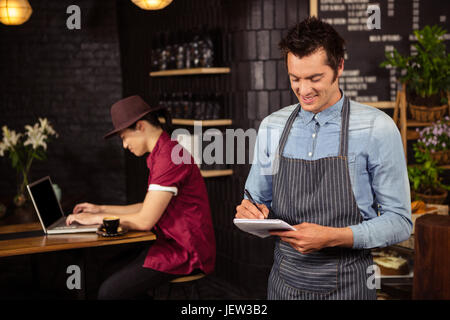 Waiter writing down the orders Stock Photo