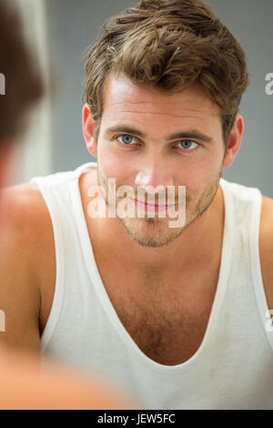 Young man looking at himself in mirror Stock Photo