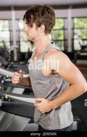 Man running on thread mill Stock Photo