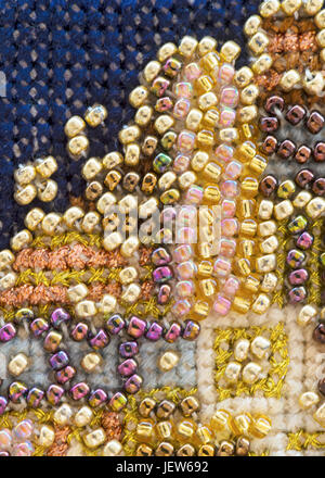 macro close up of craft background of bead embroidery in a detailed pattern, full image including cross stitch, vertical format ideal for texts  and c Stock Photo