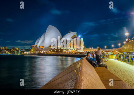 SYDNEY, AUSTRALIA - APRIL 21: Long exposure of people sitting by the Opera bar next to Sydney Opera house in the evening. April 2016. Stock Photo