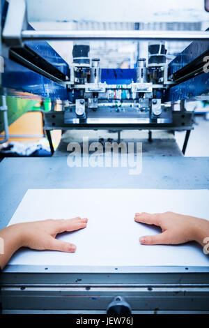 Worker preparing print screening metal machine. Industrial printer. Manufacture work. First person perspective. Stock Photo