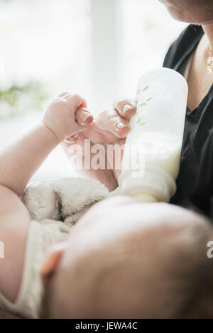 Grandmother bottle feeding baby Stock Photo