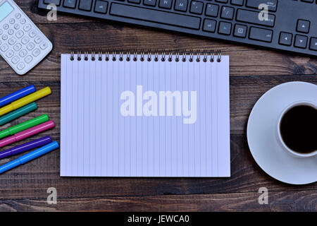 Notepad with coffee cup calculator and keyboard computer on desk Stock Photo