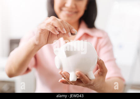 Pregnant mother and child putting coins into piggy bank Stock Photo - Alamy