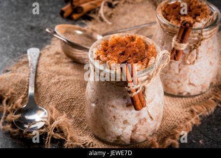 Spanish, South American, Mexican dessert. Sweet porridge, rice pudding. Arroz con leche. In portioned jars, decorated with cinnamon and sugar. On a da Stock Photo