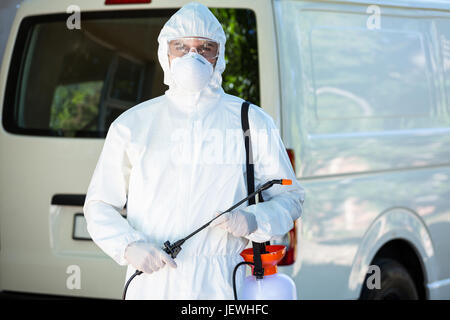 Pest control man standing behind a van Stock Photo