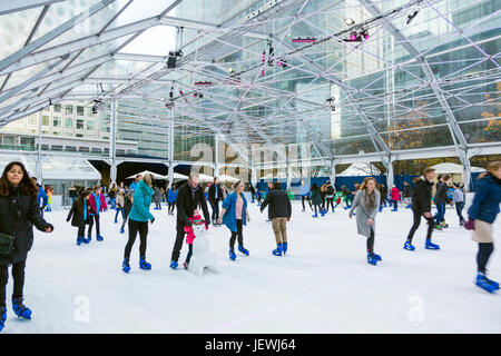 People ice skating on an ice rink in Canary Wharf, London, UK Stock Photo