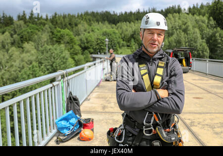 Plauen, Germany. 13th June, 2017. Thorsten Lermer, head of a rope access business in Chemnitz, stands on the crest of the wall of the Werda dam near Plauen, Germany, 13 June 2017. Mr Lermer and his crew of up to ten do all kinds of rope access work wherever scaffolding or lifts are impractical or too expensive to be deployed: facade cleaning, changing of shutter motors, inspection of bridge strutings or even cleaning of dams like the Werda dam. The men remove leaves, moss, grasses and tree shoots from the gaps and seams. Photo: Jan Woitas/dpa-Zentralbild/dpa/Alamy Live News Stock Photo