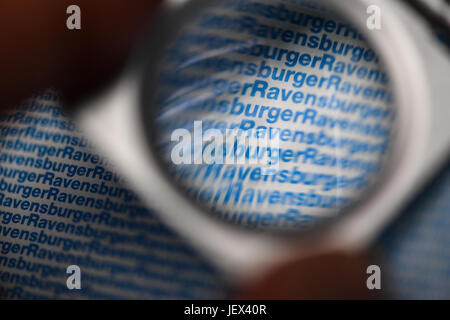 Ravensburg, Germany. 27th June, 2017. The logo of game manufacturer Ravensburger seen through a magnifying glass at the offices of Ravensburger in Ravensburg, Germany, 27 June 2017. The company will present its financial figures for the past year at a financial statement press conference on 28 June 2017. Photo: Felix Kästle/dpa/Alamy Live News Stock Photo