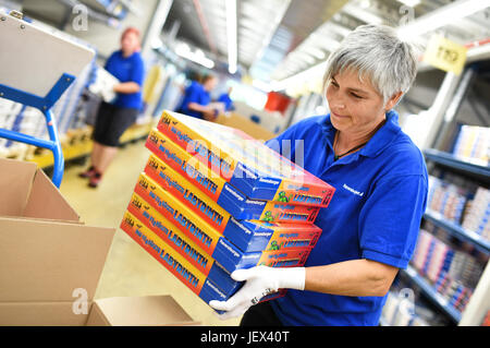 Ravensburg, Germany. 27th June, 2017. ILLSUTRATION - Ravensburger employee Petra Kienle carries several game packages in the facilities of Ravensburger in Ravensburg, Germany, 27 June 2017. The company will present its financial figures for the past year at a financial statement press conference on 28 June 2017. Photo: Felix Kästle/dpa/Alamy Live News Stock Photo