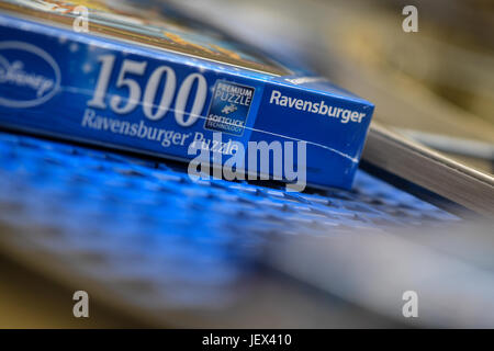 Ravensburg, Germany. 27th June, 2017. A shrink wrapped jigsaw puzzle rolls conveyor belt at the facilities of Ravensburger in Ravensburg, Germany, 27 June 2017. The company will present its financial figures for the past year at a financial statement press conference on 28 June 2017. Photo: Felix Kästle/dpa/Alamy Live News Stock Photo