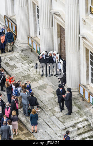 Cambridge, England. 28 June 2017. Dressed in their academic robes, students from Trinity college, University of Cambridge, pose for a photograph outside Senate House after their graduation ceremony on 28 June 2017 Credit: Michael Foley/Alamy Live News Stock Photo