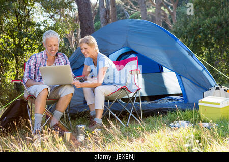 Senior couple relaxing beside their tent Stock Photo