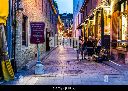 Montreal, Canada - May 27, 2017: Old town area with people eating Dairy Queen ice cream during evening outside alley in Quebec region city Stock Photo