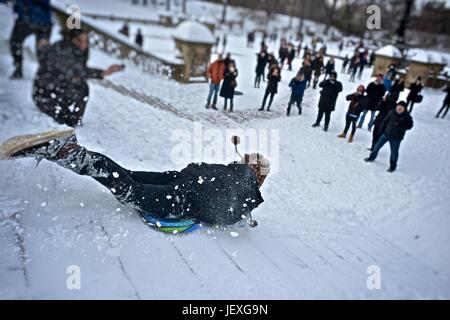 Sledding down the stairs at the Bethesda Fountain in Central Park in the aftermath of winter storm Juno. Stock Photo