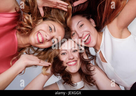 Three happy woman friends looking down. Frienship between girls Stock Photo