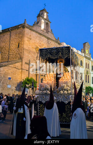 Linares, Jaen province, SPAIN - March 17, 2014: Nuestra Señora de los Dolores passing by the church of San Francisco with the candeleria illuminated c Stock Photo