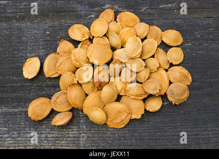 Bitter apricot kernels in wooden background Stock Photo