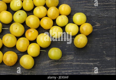 Overhead view of yellow plums on a wooden table Stock Photo