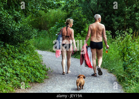 Active aging Senior couple walking dog on the road to the river, a summer holiday in Berounka river valley, Czech Republic daily life Senior man woman Stock Photo