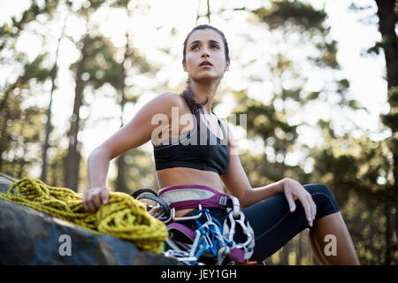 Woman sitting with climbing equipment Stock Photo