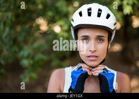 Woman fastening her cycling helmet Stock Photo