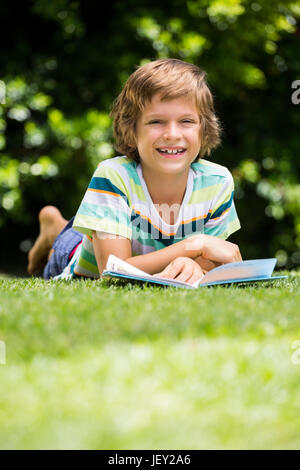 A little boy is lying down in the grass Stock Photo