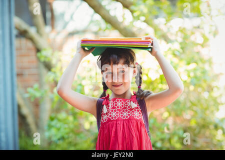 Girl holding books on her heads Stock Photo