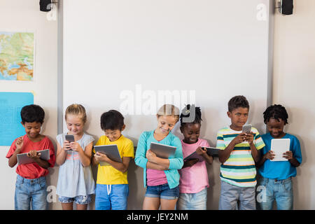 Pupils standing with technology Stock Photo